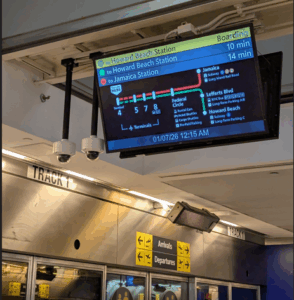 An image of the train monitor board at JFK terminal 4, announcing the arrival of Howard Beach and Jamaica trains.