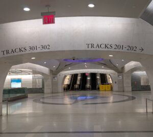 A view of the lower level of Madison Concourse, with access to the 200-level and 300-level tracks at the bottom of an escalator.